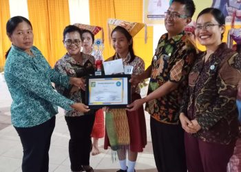 Ny. Ratnawati Sidabutar Radiapoh Hasiholan Sinaga Serahkan Trophy Juara 1 Marturiturian Bahasa Simalungun